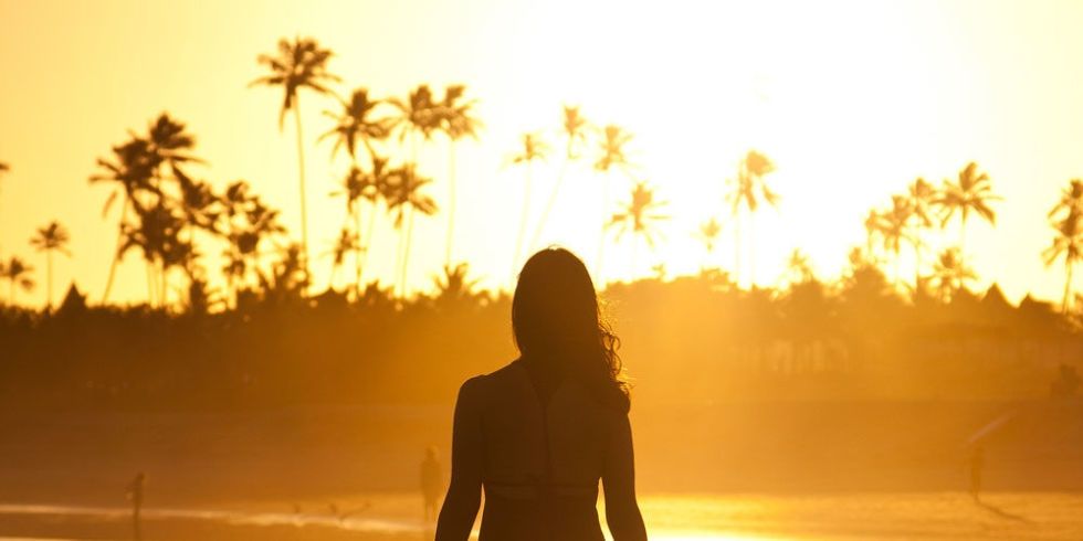 landscape-1477561984-woman-walking-sunset